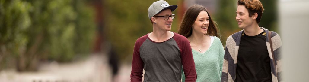 Two people standing with tote bags smiling at the camera